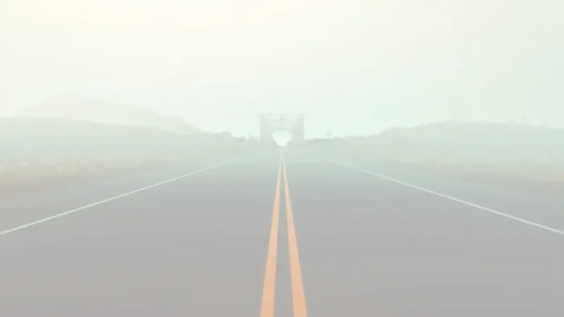 The road disappearing into thick white fog