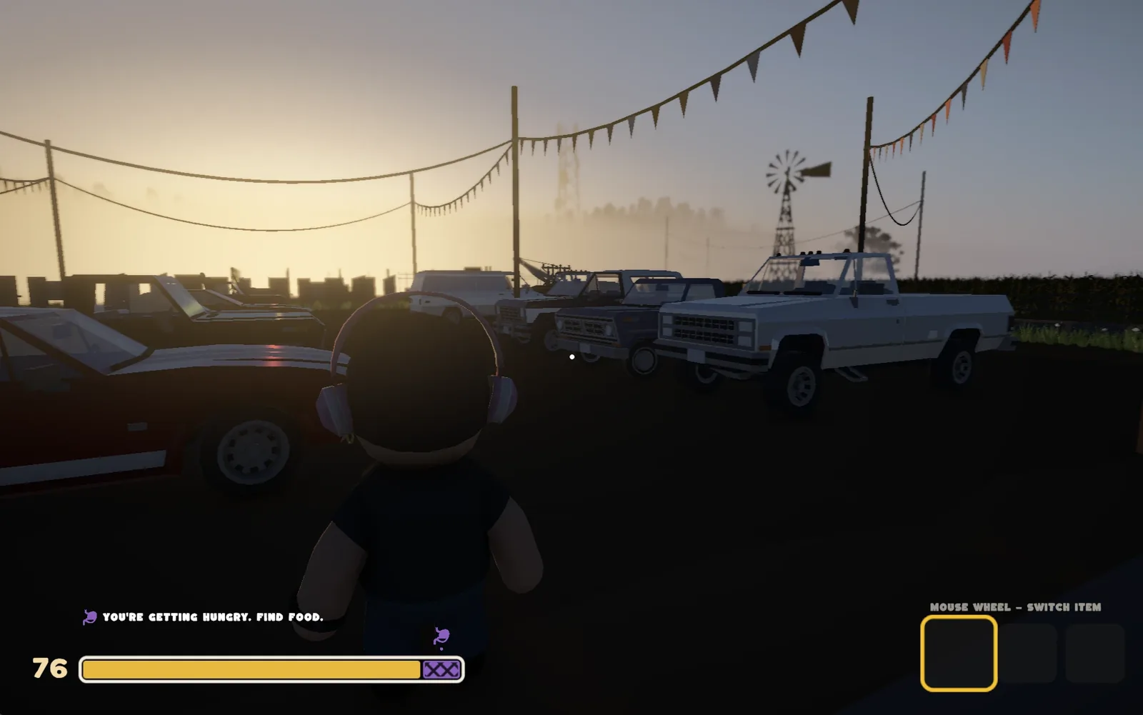 Third-person view of a player with headphones among parked pickup trucks at sunset
